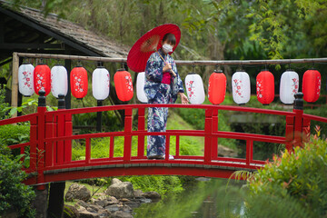 Japanese women with masks and beautiful dresses casual Yukata Kimono and red umbrellas wear...