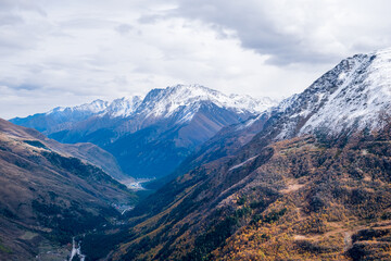 View from above on the slopes of the mountains, overgrown with forest in autumn. Mountains, tourism. Autumn colors. Selective focus.