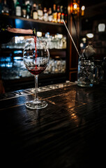 bartender hold red wine into a glass in cafe or bar