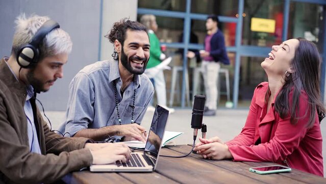 Young man interviewing a woman in a casual radio studio outdoors. High quality photo