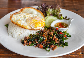 Spicy fried pork with basil leaves, the famous Thai food served with jasmine rice and fried egg.