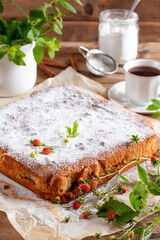 Traditional apple pie on a white plate on a wooden table. Charlotte pie on a platter. Delicious homemade pastry on the table. Top view