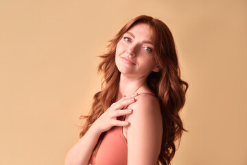  Portrait of a beautiful woman with red hair on a beige background. The beauty of a woman.