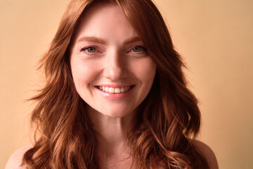 Close-up portrait of a beautiful woman with red hair smiling.