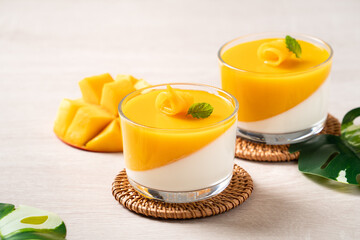 Delicious double colored mango panna cotta mousse pudding on wooden table background.