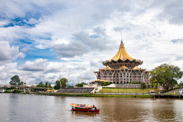 Kuching Malaysia Sep 3rd 2022: the view of Sarawak river and New Sarawak State Legislative Assembly Building. 
The cross-section of the building is designed like a nine-pointed star.