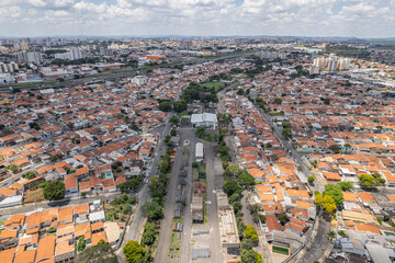 Abandoned buildings in the city of Campinas, countryside of São Paulo. Vegetation, construction debris and vehicles circulating around the residential neighborhood.