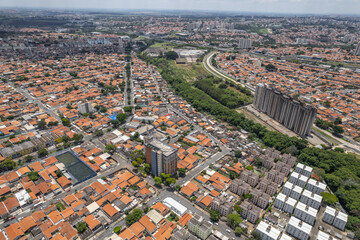 Abandoned buildings in the city of Campinas, countryside of São Paulo. Vegetation, construction debris and vehicles circulating around the residential neighborhood.