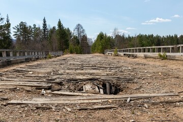 Fototapeta na wymiar Old wooden dilapidated bridge with dips