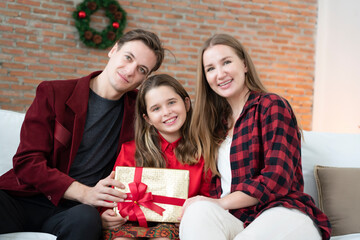 Happy family portrait photo, parent given the gift box to a daughter at Christmas Party which held at home during Christmas Festival Celebration. Holiday seasoning, Merry Christmas, Happy New Year
