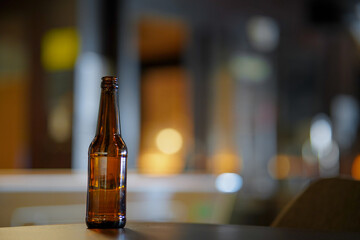 Opened beer bottle on a wooden table. Copy space, mock up.
