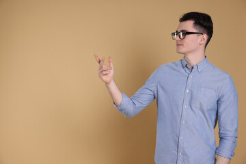 Portrait of handsome young man gesturing on beige background, space for text