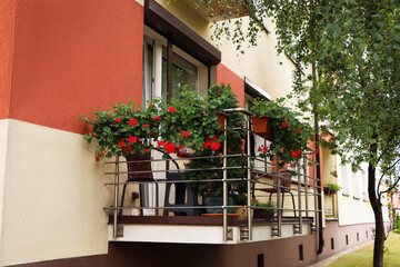 Fototapeta na wymiar Balcony decorated with beautiful red flowers and furniture