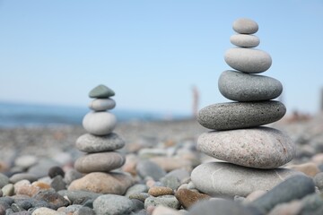 Stack of stones on beach against blurred background, closeup. Space for text