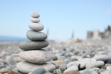 Fototapeta na wymiar Stack of stones on beach against blurred background, closeup. Space for text