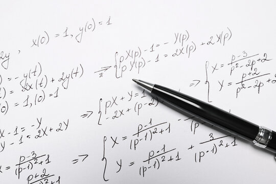 Sheet of paper with mathematical formulas and pen, closeup