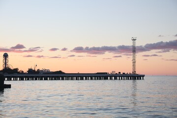 Picturesque view of pier in sea under beautiful sky at sunset