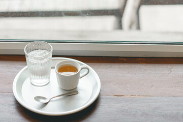 Espresso with a cool water on the table is a good meal on morning.
