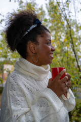 Happy African American woman drinking coffee