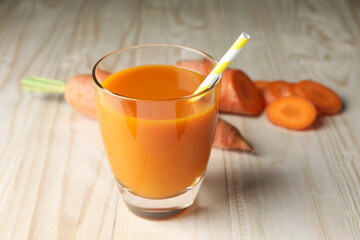 Glass of tasty carrot juice on wooden table, closeup