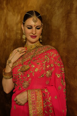 Beautiful young woman in traditional indian clothing with bridal makeup and jewelry.