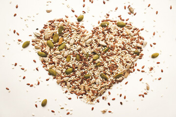 An object in the shape of a heart from a scattering of various seeds and grains.