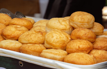 Sweet deep fried donuts are sold at a street stall. Close-up