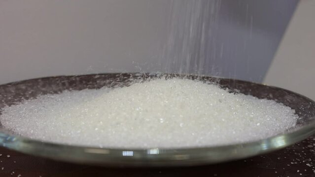 Ammonium chloride is poured into a glass dish. Concept video with chemical reagents