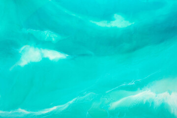 Painting background in a gentle blue color. Liquid, fluid art pattern. Original simulation of depth ocean and the sea surface. Modern design. Drawing by alcohol ink, paints.