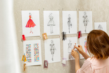 Woman fashion designer is working on creating sketches of dresses. Design and tailoring. Seamstress...