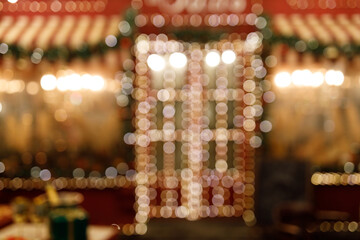 Blurry house decorated with garlands in the New Year's style. Beautiful Christmas background from bokeh.