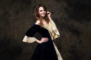 Fototapeta na wymiar Happy beautiful woman in renaissance royal dress on abstract dark background