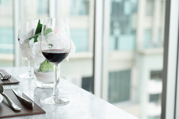 Red wine in glass on table at restaurant hotel with city background