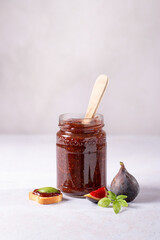 Fig jam or fig marmalade on wooden board with fresh, ripe figs