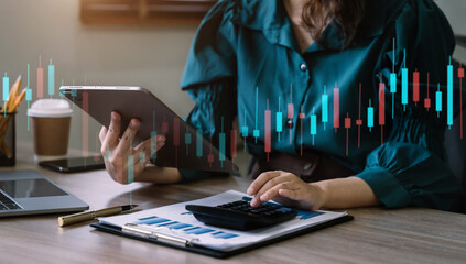 Business women working with tablet and using a calculator to calculate the tax of static in office....