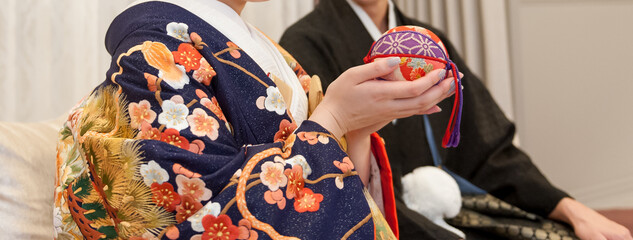 和装の花嫁と羽織袴の新郎　鞠を手に持つ新婦