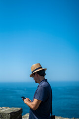 Caucasian man with a hat cheeking the phone in San Sebastian