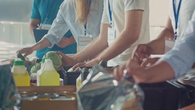 Close-up. Hands of Volunteers Sorting Humanitarian Aid at Distribution or Refugee Assistance Center. The Concept of Social Aid. Internally Displaced Persons. Charity Project or Donating Aid