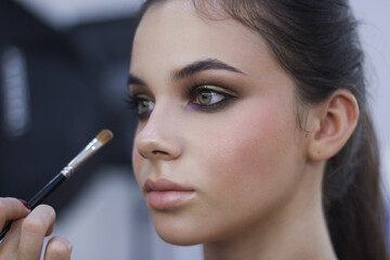 Obraz premium woman applying makeup by brush