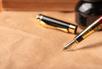 Fountain pen, detail of a beautiful fountain pen resting on rustic paper, selective focus.