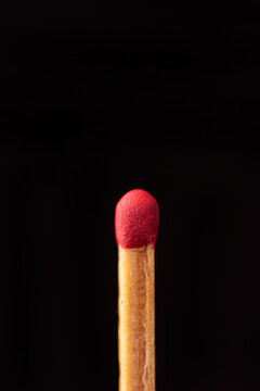 Matchstick in detail seen through a macro lens, black background, selective focus.