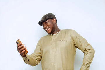 Handsome young African man smiling looking at mobile phone in hand