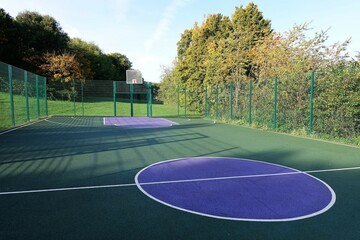 Fenced basket ball court with artificial surface