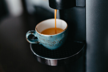 Preparing espresso with a coffee machine. Process of pouring coffee at cup. Cup of coffee close-up....
