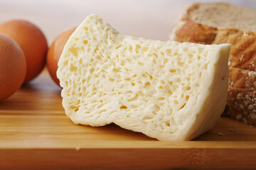 Close up of cheese, milk , brown bread and almond nut on table.