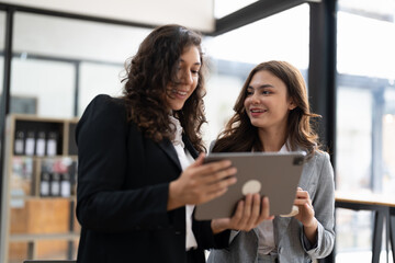 Diverse businesspeople cooperate work together discussing company financial statistics, multiracial colleagues collaborate brainstorm with finance on tablet.
