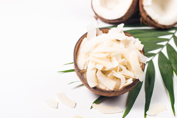 Coconut chips with coconut and green leaves on a white background. Isolated concept.