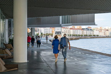 Adult couple walking along the Sefront in Santander