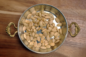 Peeled raw almonds in a copper pan
