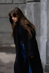 A young beautiful woman in a black coat